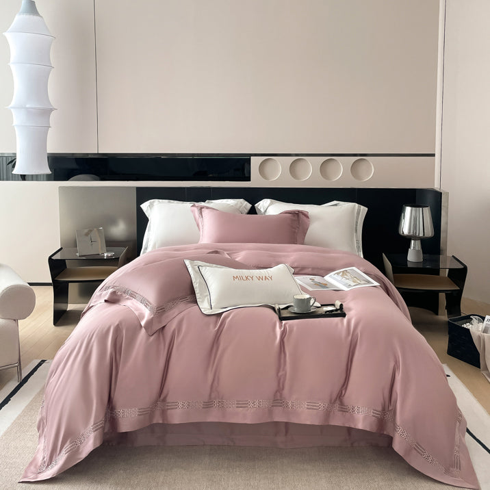 Tencelio patalynės komplektas su subtiliais siuvinėjimais, elegantiškai papuoštas moderniame miegamajame. Minkšta, kvėpuojanti ir hipoalerginė tencelio patalynė, suteikianti prabangų komfortą.